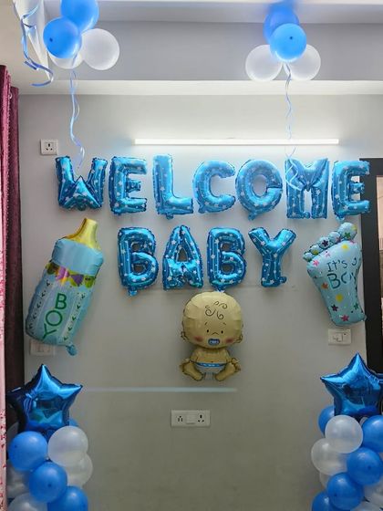 A clean and simple wall decoration to welcome a baby boy. The 'Welcome Baby' foil balloons are the centerpiece, supported by balloon pillars and star-shaped foils.
