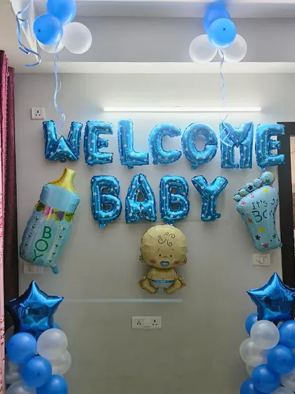 A clean and simple wall decoration to welcome a baby boy. The 'Welcome Baby' foil balloons are the centerpiece, supported by balloon pillars and star-shaped foils.