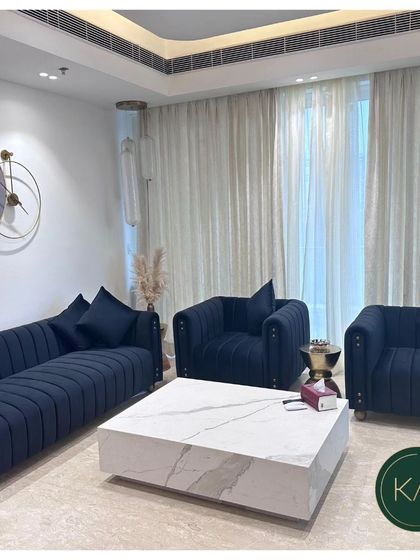 We designed this living room to feel both luxurious and welcoming. The deep navy blue, channel-tufted sofa and matching armchairs are paired with a solid marble block coffee table, creating a bold, contemporary look grounded in classic comfort.