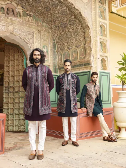 Coordinate with your groomsmen in style. This image displays three distinct yet harmonious looks, each featuring a solid kurta paired with a unique, richly embroidered Nehru jacket. It’s the perfect inspiration for a cohesive and fashionable wedding party.