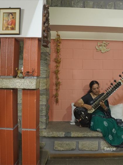 At the V S Sreedhara Residence, a quiet corner is dedicated to music. The design incorporates built-in seating and uses a mix of stone and terracotta to create a warm, acoustically pleasant space.