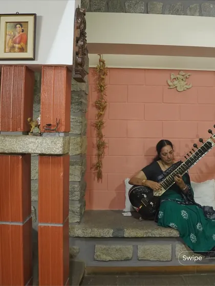 At the V S Sreedhara Residence, a quiet corner is dedicated to music. The design incorporates built-in seating and uses a mix of stone and terracotta to create a warm, acoustically pleasant space.
