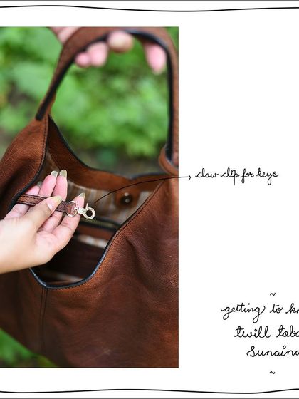 A close-up of the claw clip for keys inside the Twill Tobacco Sunaina, a small but essential feature for organization.