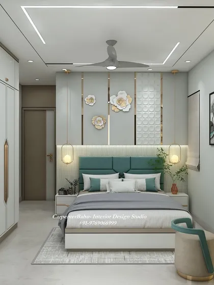 This bedroom uses a refreshing teal color for the headboard, which is complemented by gold and white floral wall art. The wardrobe has a unique, modern design with integrated handles.