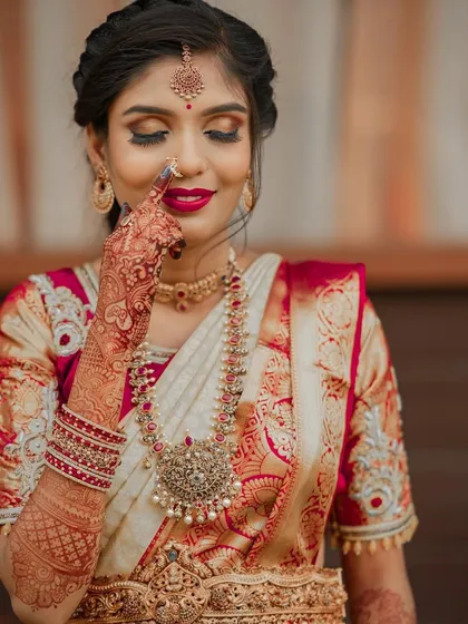A close up shot showing the intricate details of her makeup and henna. The eye makeup has a touch of shimmer to catch the light.