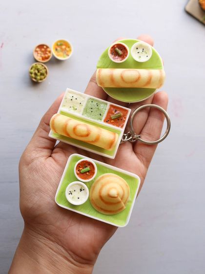 Three different styles of dosa miniatures: a platter, a keychain, and a cone dosa.
