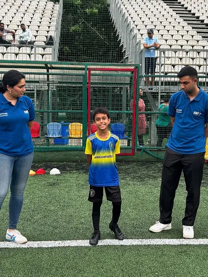 A young player stands proudly between two sports psychology experts after a session. This photo captures the positive and supportive learning environment we create.