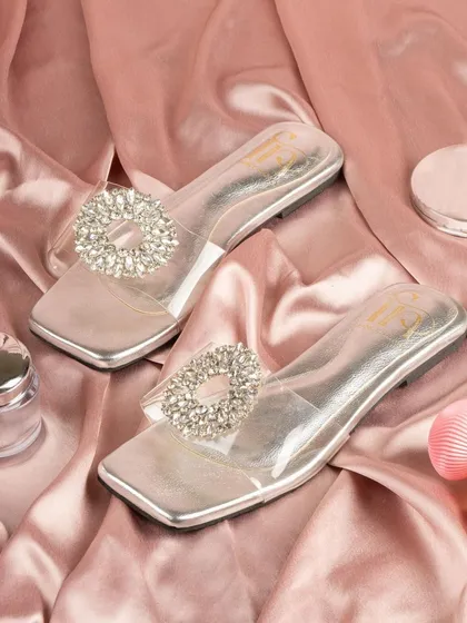 A pair of silver flats with a crystal buckle for Fancy Nancy. The elegant styling on pink silk makes this simple footwear look glamorous and special.