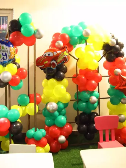 Indoor decorations for a Cars party, featuring a smaller balloon arch with a Lightning McQueen foil balloon. I can adapt any theme for our indoor or outdoor spaces.