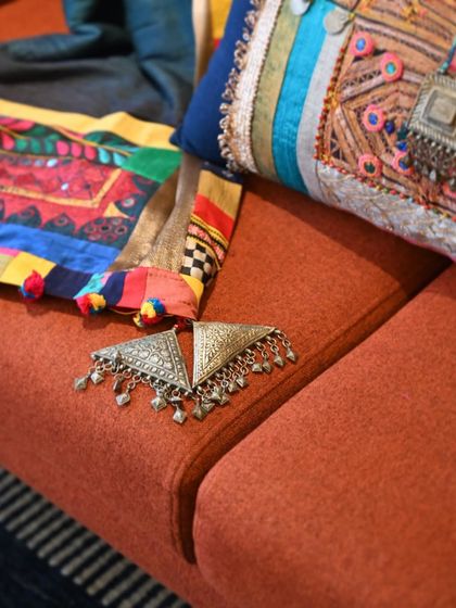 A detail shot of the old silver jewelry pieces used to embellish the Banjara textiles. These found objects add an authentic, historical touch to the final creation.