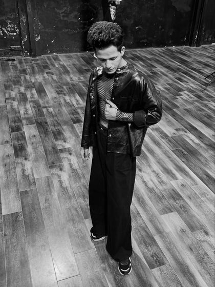 A pensive, downward-looking pose in black and white, highlighting the details of the outfit and creating a thoughtful mood.