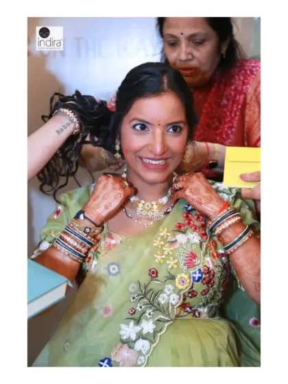 The mother-to-be getting ready, a candid shot of family helping her with her jewelry. These behind-the-scenes moments are part of the story.