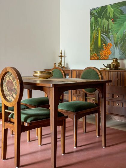The dining set at Layam, featuring chairs with a medley of wood, brass, and a dual-fabric approach for practicality and visual appeal. The chest of drawers behind it has details that resemble the "beats" of music.