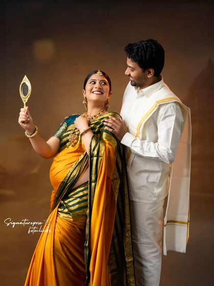 A sweet, interactive pose where the couple shares a look of admiration, set against a traditional backdrop.