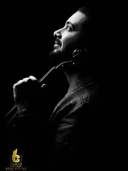 In our studio, we control every element of light and shadow to create powerful, artistic portraits. This dramatic black and white photograph of a musician with his violin uses a low-key lighting technique to sculpt his features and convey a deep sense of passion and introspection.