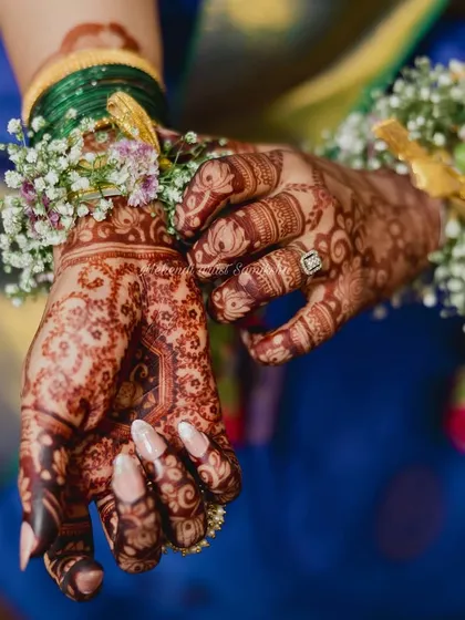 A beautiful shot of a baby shower mehendi, complemented by fresh floral jewelry. The dark stain looks stunning.