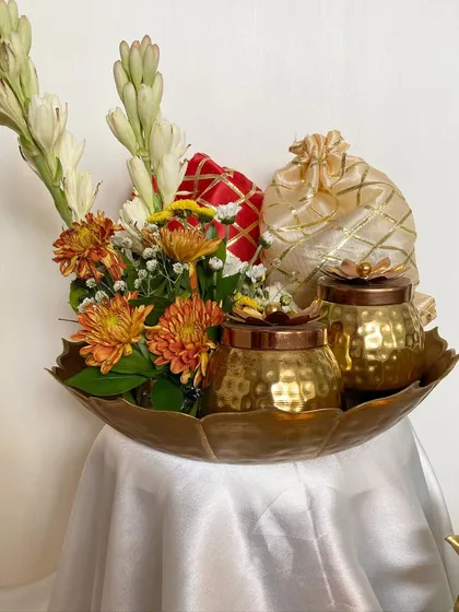 A different angle of the traditional urli hamper, showing the beautiful arrangement of tuberoses and chrysanthemums.