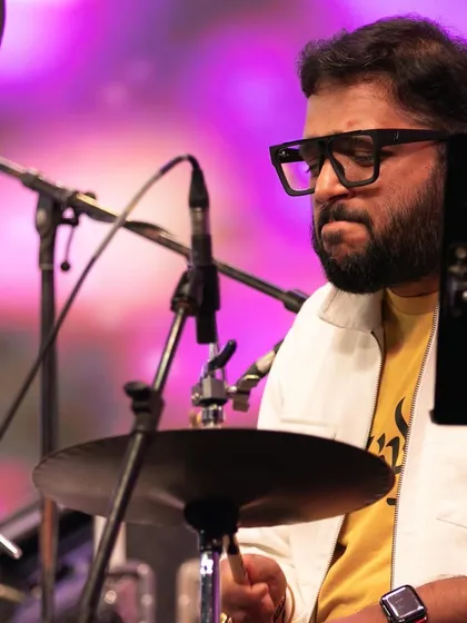 Our drummer, fully engaged in the rhythm at the Bengaluru Ganesh Utsava. His powerful playing drives the high-energy sections of our fusion concerts.