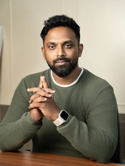 A clean and confident professional headshot, perfect for making a strong impression on LinkedIn or a company website. The focus here is on approachability and professionalism, achieved with simple studio lighting and a relaxed, direct-to-camera pose.