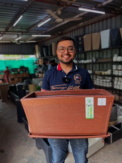 Holding up one of my popular and versatile 'kishti' planters, perfect for balconies and small gardens.