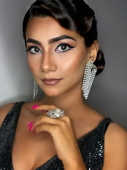 A full-face portrait that captures the entire look, including the statement earrings and sleek hair that complete this glamorous style.