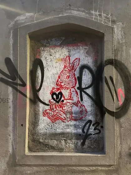 A quick tag over a stencil of a rabbit in an old wall niche. This shows the layering that happens in the streets, with artists painting over and around each other's work.