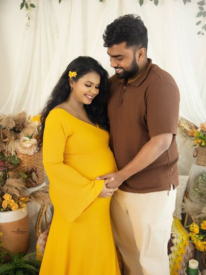 A sweet and candid moment as a couple shares a smile. Their hands meet on the baby bump, symbolizing their shared love and excitement.