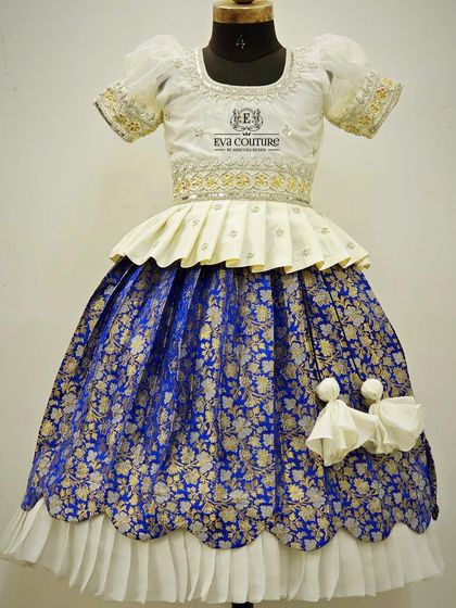 Another view of the white and royal blue Banarasi lehenga, showing the scalloped hem of the skirt.