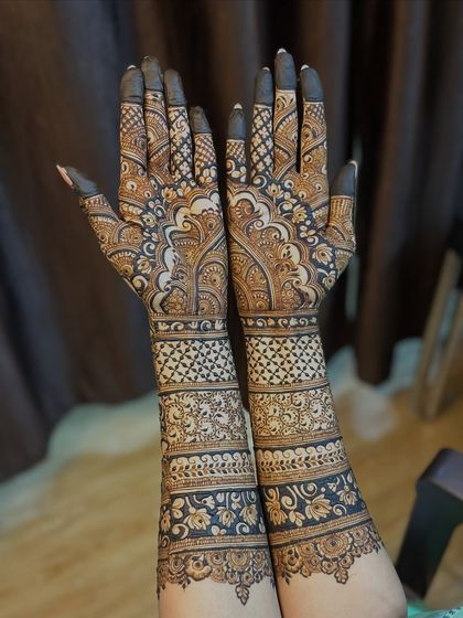 A gorgeous full-hand design with a mix of floral bands, geometric grids, and paisleys. The symmetry between the two hands is key to this look.