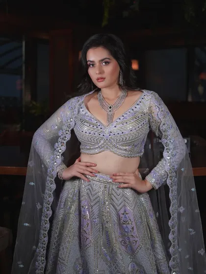 A powerful pose from Tanvi Negi's reception look shoot. The makeup, with its purple smokey eye and flawless base, is designed to be bold and memorable.