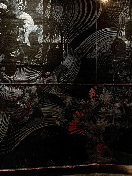 A close-up of the 'Gothilicious' textile, highlighting the rich textures and moody color palette. The piece is designed to be both sensual and sensorial.