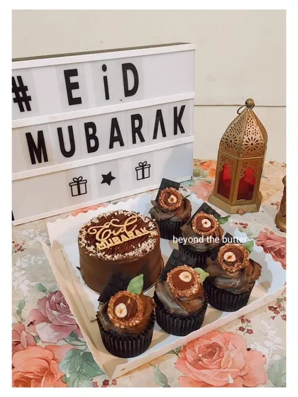 A chocolate-themed Eid bento box. This set includes a 4-inch chocolate cake with an "Eid Mubarak" topper and five matching chocolate cupcakes.