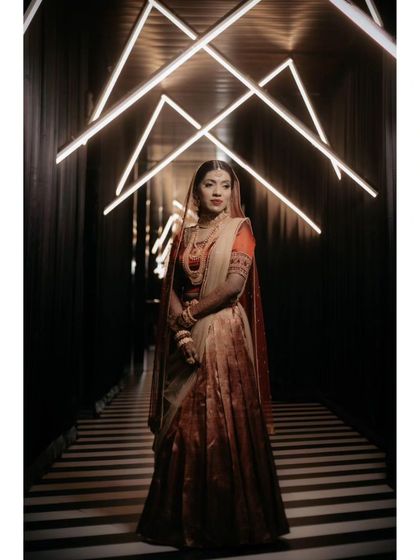 A stunning full-length portrait of Alka in a dark, modern corridor with geometric lighting, creating a high-fashion, dramatic look.