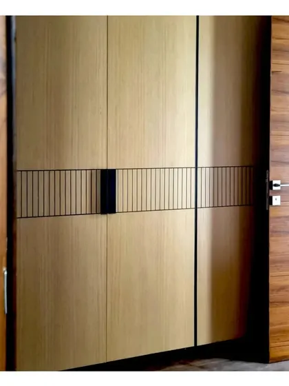 A custom walk-in wardrobe with a light veneer finish and a sleek, minimalist handle detail, combining elegance with practical storage.