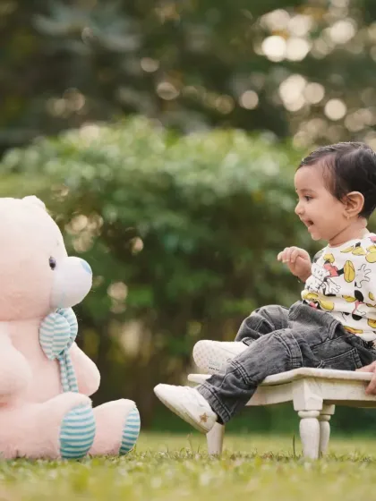 A playful conversation with a teddy bear. I aim to capture the imaginative world of children during my outdoor photography sessions.