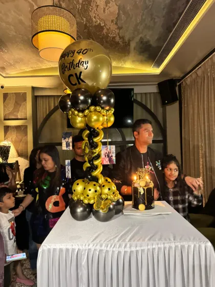 Celebrating a 40th birthday in style. This setup features a classy black and gold balloon column with a personalized "Happy 40th Birthday" balloon and a matching cake.