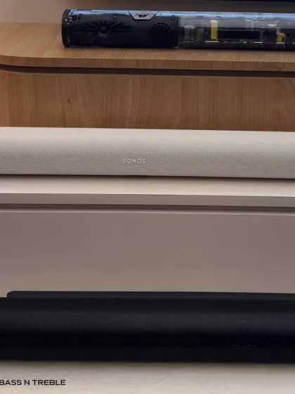 A close-up of the Sonos soundbars in black and white finishes. The fabric grille and minimalist design allow them to blend seamlessly below a television, while the technology inside delivers a surprisingly powerful audio experience.