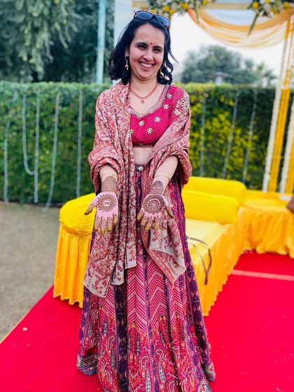A full-length photo of the client, showing how her elegant mehndi complements her festive attire.