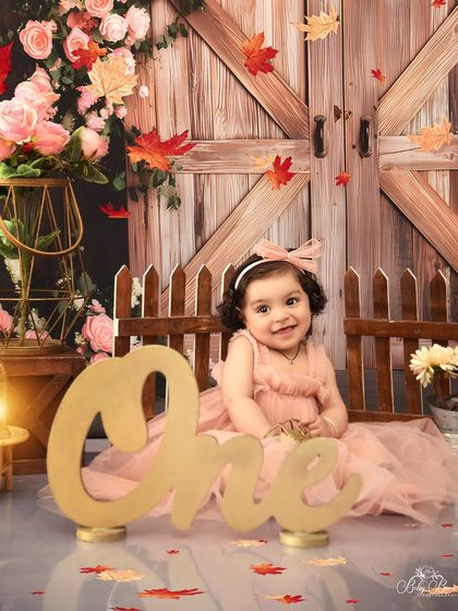A rustic barnyard theme for a sweet first birthday girl. The combination of soft pink, florals, and wooden textures makes for a charming and pretty portrait.