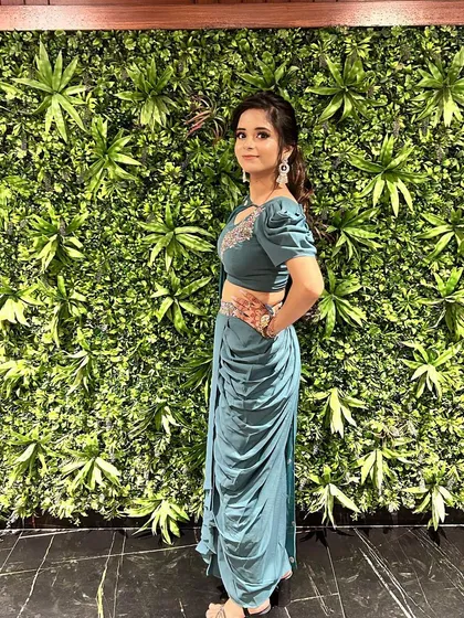 A beautiful client looking chic in our teal draped dhoti set. The puff sleeves and embroidered details on the blouse add a modern and stylish touch.