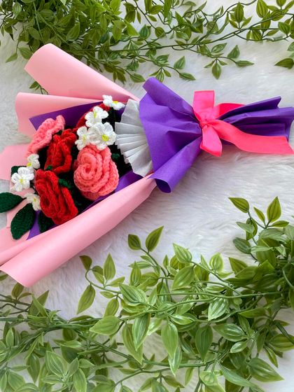 This sweetheart bouquet, with its mix of red and pink roses, is laid out to show the beautiful color combination against the pink and purple wrapping. It’s a bright and lovely arrangement.