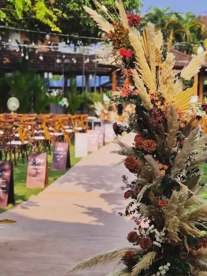 Another perspective of the wedding aisle, focusing on the texture and color of the pampas grass arrangements that line the walkway. The soft lighting adds to the dreamy, romantic feel of the ceremony.
