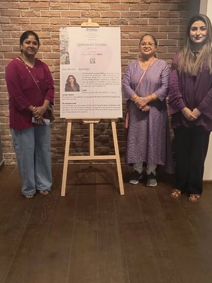 The opening day of 'Ephemeral Dreams', with the artist and guests gathered around the exhibition poster.