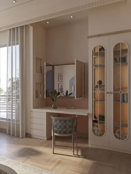 This view showcases the room's thoughtful layout, including a dedicated vanity area with a tri-fold mirror and a glass-paneled display cabinet, blending functionality with classic design elements.