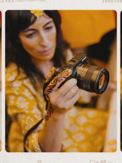 A creative shot focusing on the tools of my trade. This image, with a camera held by a hand adorned with Haldi and henna, symbolizes my passion for capturing wedding traditions.