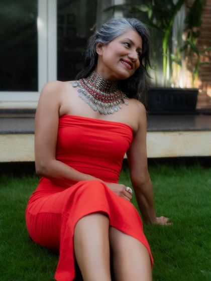 A close-up of the red dress and statement necklace, showing the beautiful contrast in colors and textures.