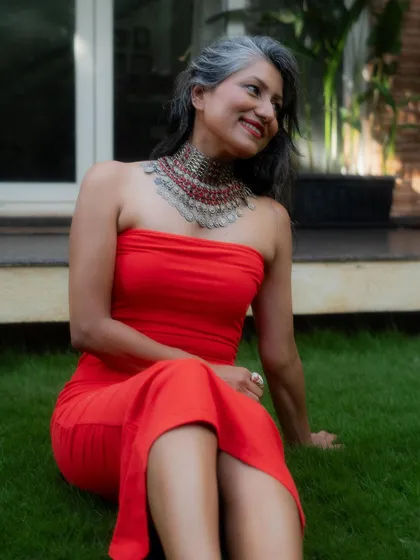 A close-up of the red dress and statement necklace, showing the beautiful contrast in colors and textures.