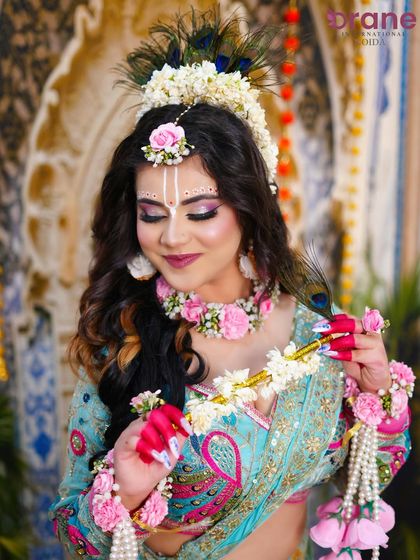 This portrait showcases the intricate floral jewelry and the traditional tilak, key elements of the Radha look.