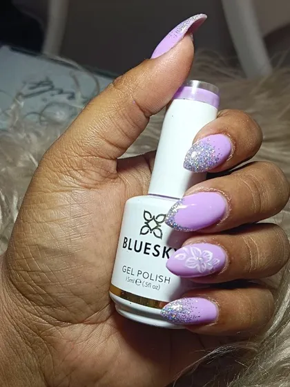 A close-up of the lilac and glitter Eid nails, holding a bottle of the gel polish I used.
