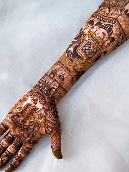 A single arm view of a magnificent storytelling mehndi, with panels showing the groom's portrait, doli, and other wedding elements.